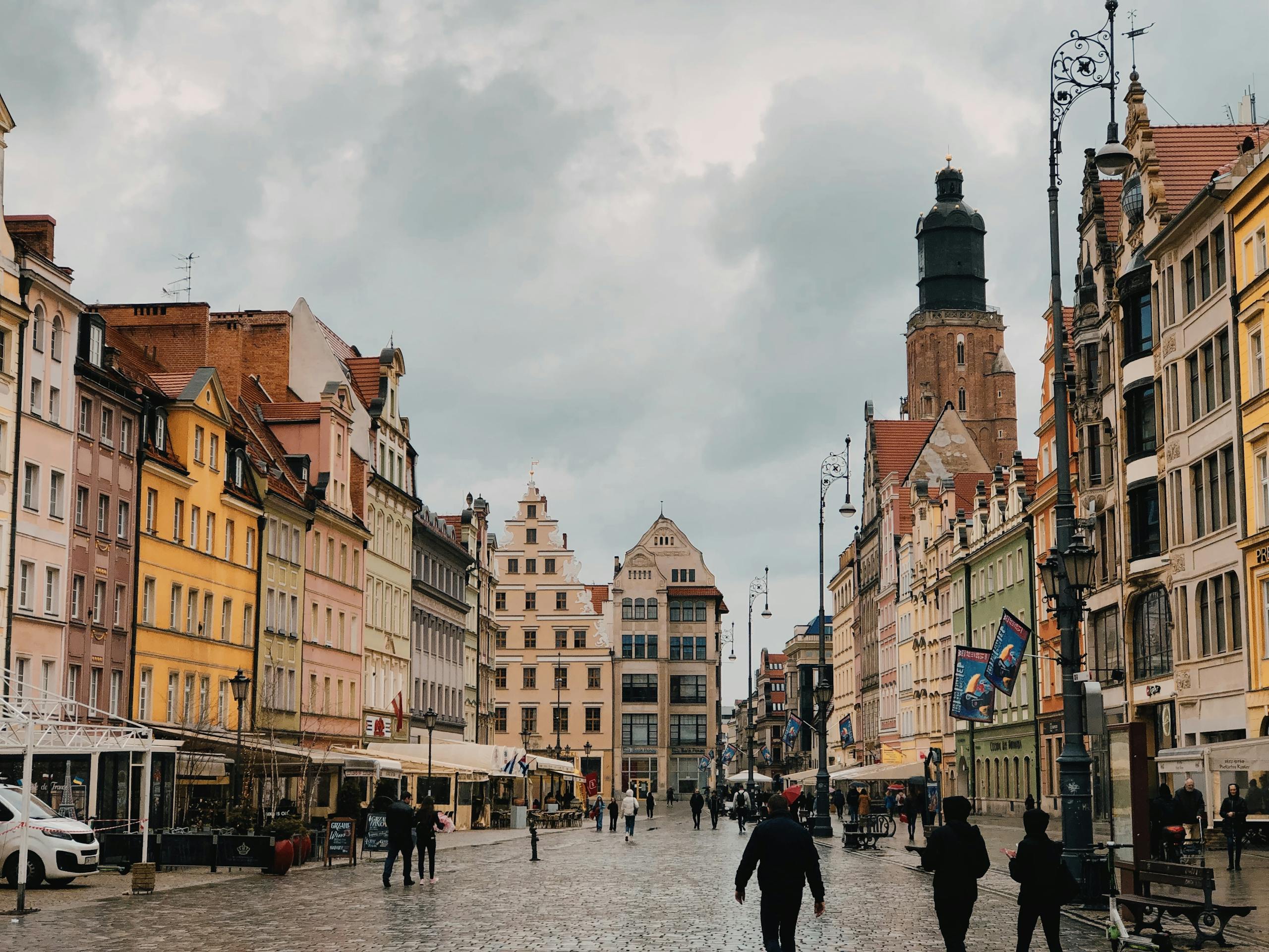 People walking down a cobblestone street in a city