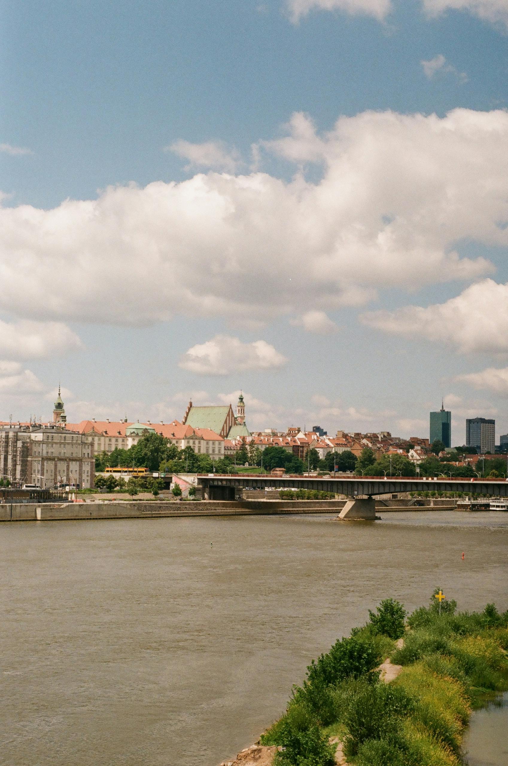 A river with buildings in the background and a bridge