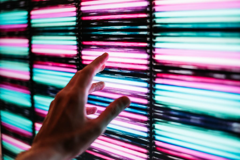 Person's Hand Touching Blue and Pink Led Panel