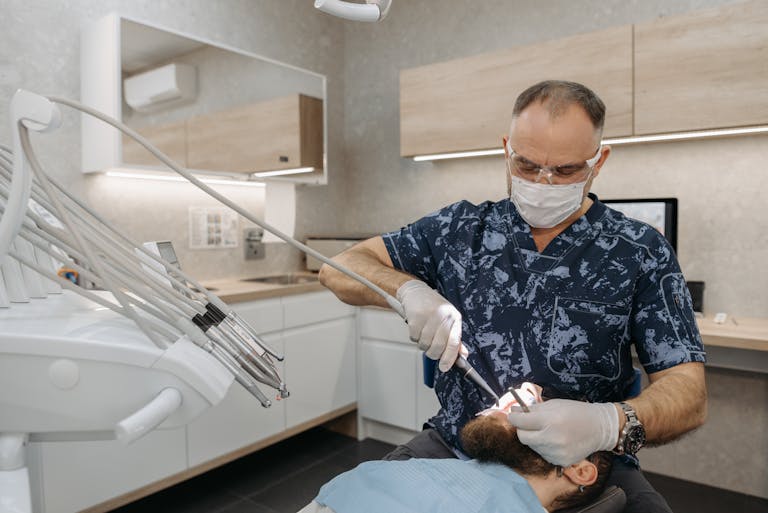 Dentist performing a routine dental examination on a patient in a modern clinic setting.